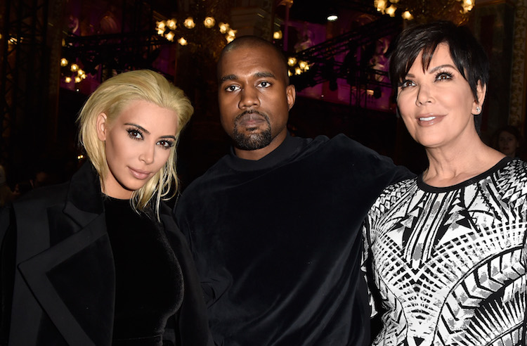 Kim Kardashian with blonde hair sitting with Kanye West and Kris Jenner