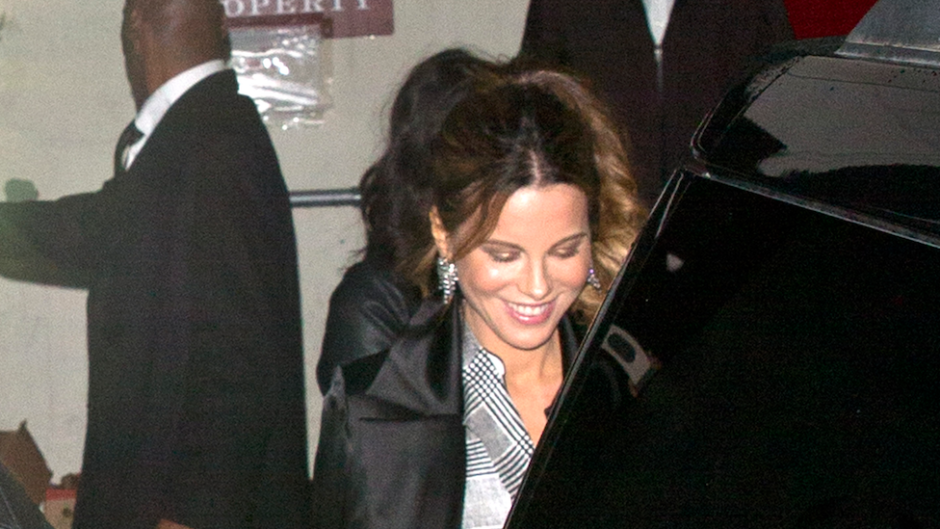 Kate Beckinsale smiling while getting into a black car