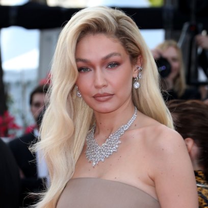 GIgi Hadid poses in a tan dress and silver necklace